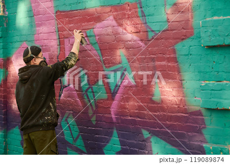 Guy creating graffiti artwork on street Guy creating graffiti artwork on street 119089874