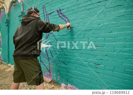 Applying purple paint on green wall Applying purple paint on green wall 119089912