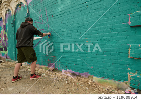 Man creating new artwork on green wall Man creating new artwork on green wall 119089914