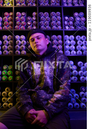 Guy by neon lit display with cans Guy by neon lit display with cans 119089936