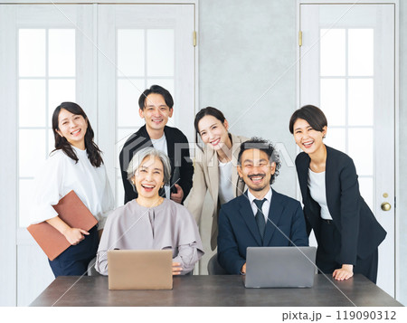 オフィスで笑う幅広い世代のビジネスパーソンのチーム オフィスで笑う幅広い世代のビジネスパーソンのチーム 119090312