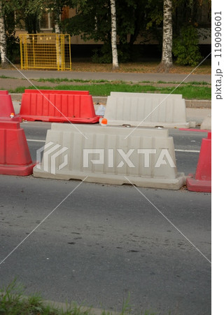 Red, white plastic safety barriers along roads. Ensuring road safety with visible barriers Red, white plastic safety barriers along roads. Ensuring road safety with visible barriers 119090601