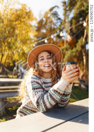 Fall concept woman drinking coffee on bench against backdrop of lake. Enjoying, solitude with nature Fall concept woman drinking coffee on bench against backdrop of lake. Enjoying, solitude with nature 119090702
