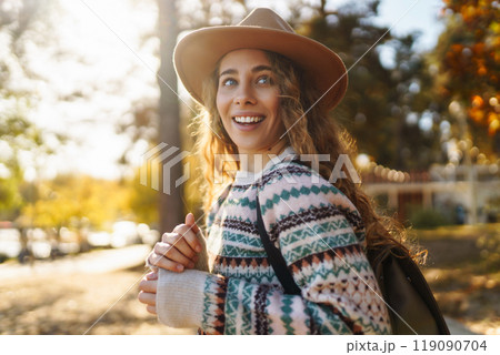 Stylish woman enjoying autumn weather in the sunny park. Enjoying nature. Fashion, style concept. Stylish woman enjoying autumn weather in the sunny park. Enjoying nature. Fashion, style concept. 119090704