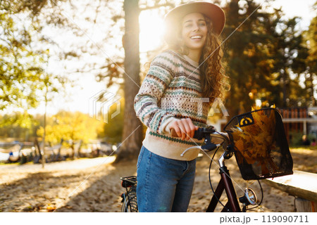 Happy active young woman on bike in autumn park at sunset. Concept of people, recreation, active lifestyle. Happy active young woman on bike in autumn park at sunset. Concept of people, recreation, active lifestyle. 119090711