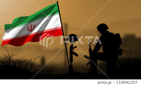 The silhouette of an Iranian soldier weeps for the loss of a comrade in battle, with a large flag waving 119092207
