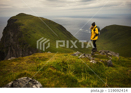 A Female Hiker Standing Proudly on a Mountain Peak Surrounded by the Splendor of Nature 119092414