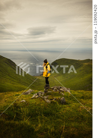 An Adventurous Hiker Standing Proudly on a Scenic Mountain Peak Overlooking Breathtaking Views An Adventurous Hiker Standing Proudly on a Scenic Mountain Peak Overlooking Breathtaking Views 119092420