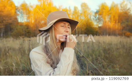 Cold and health, sick mature woman coughing outdoors in autumn park, fall season 119092769