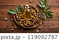 Jojoba oil and jojoba plant in wooden plate on wooden backgrounds 119092787
