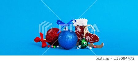 Christmas ball with skates on colored background. decoration bauble with ribbon bow with copy space Christmas ball with skates on colored background. decoration bauble with ribbon bow with copy space 119094472