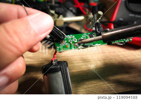 Soldering electronic boards using an electric soldering iron and soldering lead by an electrician 119094588