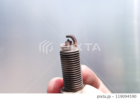 Dirty and damaged spark plugs of car combustion engine in the hands of car mechanic , Car repair concept Dirty and damaged spark plugs of car combustion engine in the hands of car mechanic , Car repair concept 119094590