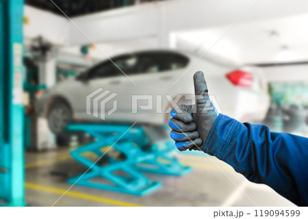 Thumb up for car repair work , The auto mechanic gives a thumb up to show confidence in a good job 119094599