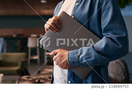 Man holding laptop in office Man holding laptop in office 119094753