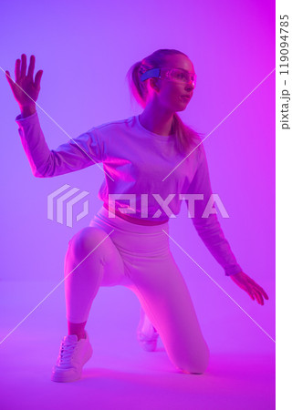 Woman interacting with virtual reality in vibrant neon colored lighting Woman interacting with virtual reality in vibrant neon colored lighting 119094785