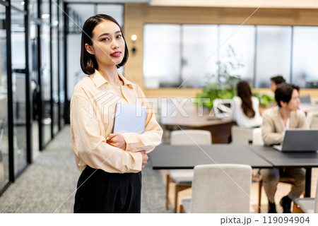 ノートパソコンを両手で抱えてカメラ目線の女性 ノートパソコンを両手で抱えてカメラ目線の女性 119094904
