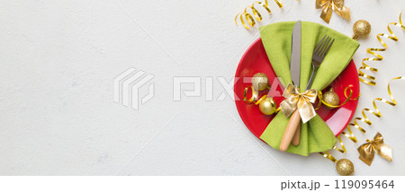 Christmas table place setting with christmas decor and plates, kine, fork and spoon. Christmas holiday background. Top view with copy space 119095464