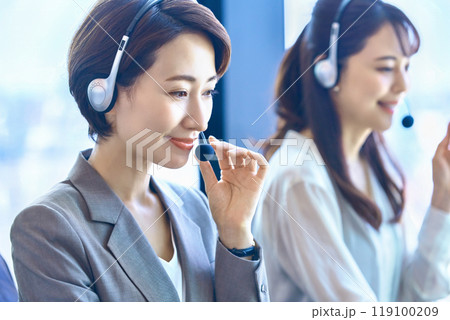 オフィスでヘッドセットをつけて対応するミドルのオペレーター 119100209