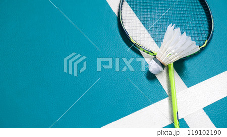 White badminton shuttlecocks and badminton rackets on green floor indoor badminton court. Concept for badminton competition and its lovers. 119102190