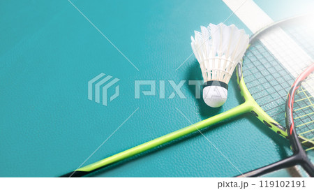 White badminton shuttlecocks and badminton rackets on green floor indoor badminton court. Concept for badminton competition and its lovers. 119102191