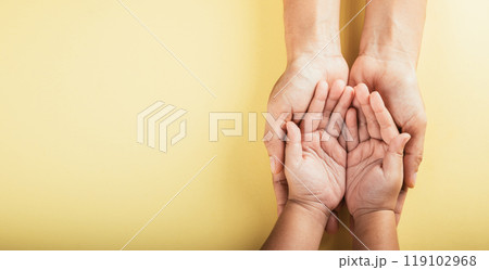 Family hands stacked in close-up top view isolated background. Parents and child holding empty space symbolize support and love. Embracing togetherness trust and community. Family hands stacked in close-up top view isolated background. Parents and child holding empty space symbolize support and love. Embracing togetherness trust and community. 119102968