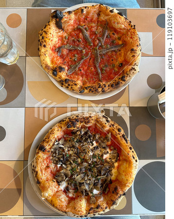 Delicious pizza served on a colorful table. Italian cuisine and diverse flavors in a casual dining experience 119103697
