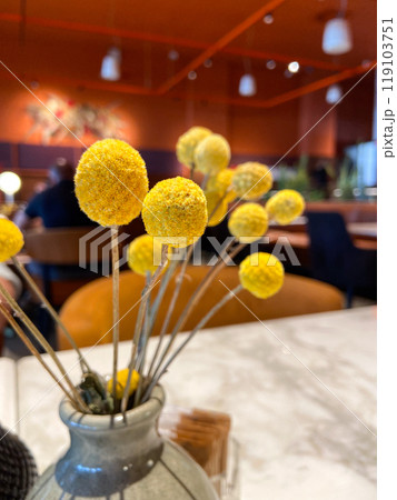 Table with decorative vase and condiment set in cozy restaurant ambiance. Warmth and elegance of a dining table setting, highlighting the intricate details of the decorations 119103751