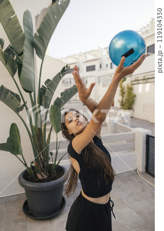 A Dynamic Woman Having Fun While Playing with a Colorful Blue Bowling Ball in a Stylish Setting A Dynamic Woman Having Fun While Playing with a Colorful Blue Bowling Ball in a Stylish Setting 119104350