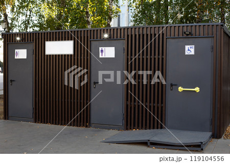 Modern public toilet on street, convenient wc for people with access for men, women and people with disabilities, accessible environment for disabled people with special ramp to toilet door Modern public toilet on street, convenient wc for people with access for men, women and people with disabilities, accessible environment for disabled people with special ramp to toilet door 119104556