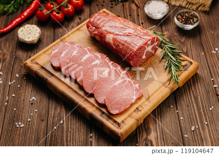Fresh raw pork loin with rosemary on a wooden cutting board, perfect for cooking or grilling recipes Fresh raw pork loin with rosemary on a wooden cutting board, perfect for cooking or grilling recipes 119104647