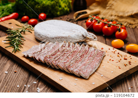 Dry-cured salami on board, ideal for rustic charcuterie presentations and gourmet food styling 119104672