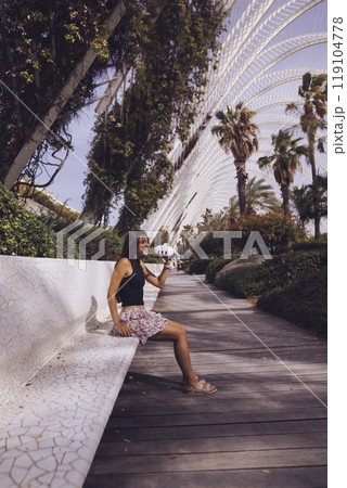 A Charming Outdoor Scene Featuring a Woman Enjoying a Beautiful Modern Garden Setting 119104778