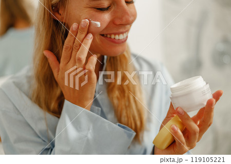 A woman gently applying moisturizer as part of her comprehensive skincare routine A woman gently applying moisturizer as part of her comprehensive skincare routine 119105221
