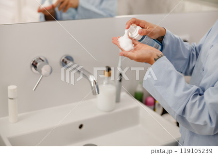 Begin your day with a refreshing skincare routine, using moisturizer for a luxurious feel 119105239