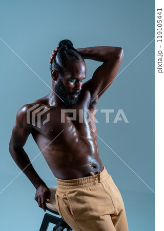 Black shirtless gay model posing while leaning on 119105441