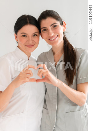 Happy female doctors making heart shape with hands Happy female doctors making heart shape with hands 119105445