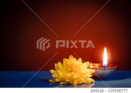 Happy Diwali. Traditional symbols of Indian festival of light. Burning diya oil lamps and flowers on red background. Copy space. Happy Diwali. Traditional symbols of Indian festival of light. Burning diya oil lamps and flowers on red background. Copy space. 119106777