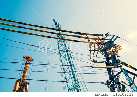 建設現場周辺の電線防護カバーと青空に伸びるクレーン b-4 暖色 建設現場周辺の電線防護カバーと青空に伸びるクレーン b-4 暖色 119108213