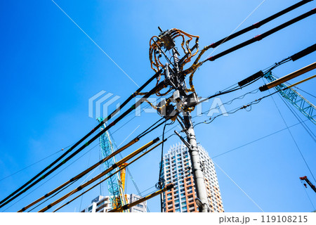 建設現場周辺の電線防護カバーと青空に伸びるクレーン　c-2 高彩度コントラスト 119108215