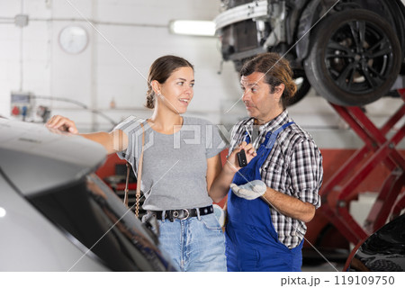 Woman client giving car keys to mechanic Woman client giving car keys to mechanic 119109750