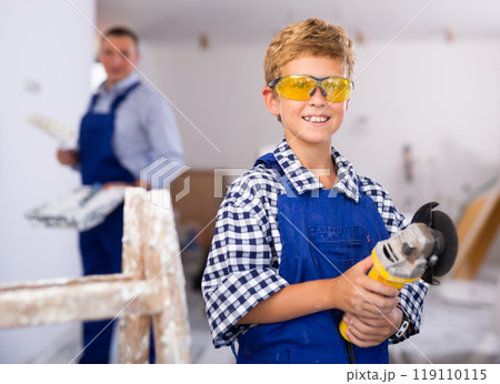 Portrait of positive young boy with angle grinder 119110115