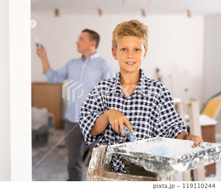 Portrait of positive boy with paint roller. Concept of helping parents to repair apartment Portrait of positive boy with paint roller. Concept of helping parents to repair apartment 119110244