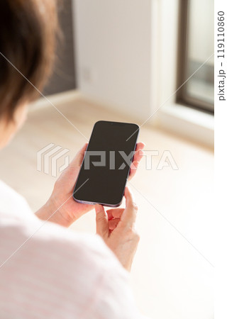 マンションの内覧でスマホを見るミドル女性 マンションの内覧でスマホを見るミドル女性 119110860