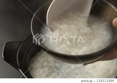 お粥　土鍋で炊いたおかゆを茶碗に盛り付ける 119111894