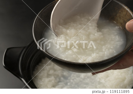 お粥 土鍋で炊いたおかゆを茶碗に盛り付ける お粥 土鍋で炊いたおかゆを茶碗に盛り付ける 119111895
