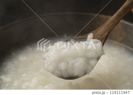 お粥　おかゆをスプーンで持ち上げる 119111947