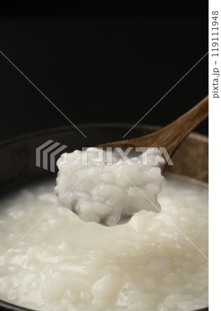 お粥　おかゆをスプーンで持ち上げる 119111948