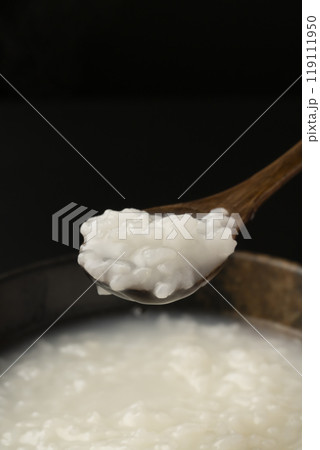 お粥　おかゆをスプーンで持ち上げる 119111950
