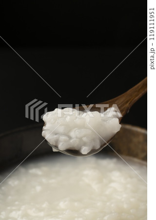 お粥　おかゆをスプーンで持ち上げる 119111951